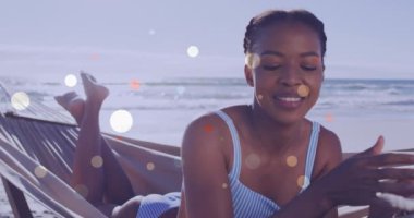 Afro-Amerikan bir kadının plajda hamakta uzanması ve dinlenmesi üzerine mercek fişeklerinin canlandırılması. Dijital bileşik, çoklu pozlama, tatil, dinlenme ve boş zaman aktivite kavramı.