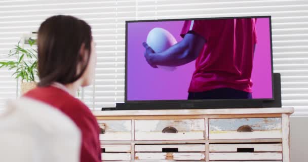 Λευκή Γυναίκα Που Βλέπει Τηλεόραση Αφροαμερικανό Παίκτη Ράγκμπι Μπάλα Στην — Αρχείο Βίντεο