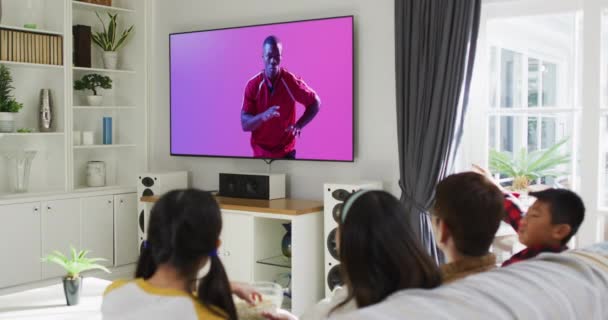 Afrikalı Amerikalı Erkek Rugby Oyuncusuyla Televizyon Izleyen Asyalı Bir Aile — Stok video