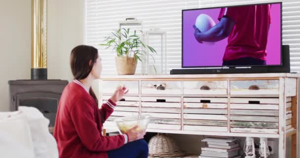 Белая Женщина Смотрит Телевизор Африканским Американским Игроком Регби Мячом Экране — стоковое видео