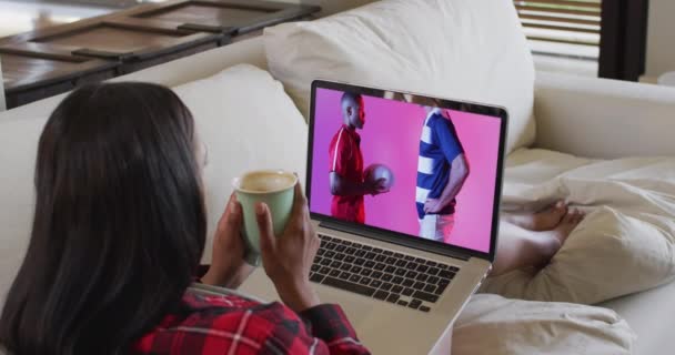 一个身材魁梧的女人在看笔记本电脑 屏幕上有各种各样的男声橄榄球手和球 通信技术和体育 数字合成录像 — 图库视频影像