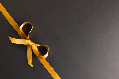 Altın hediye kurdelesi ve siyah arka planda fotokopi alanı. Kara Cuma, siber pazartesi, alışveriş, siber alışveriş, satış, perakende ve nakliye konsepti.