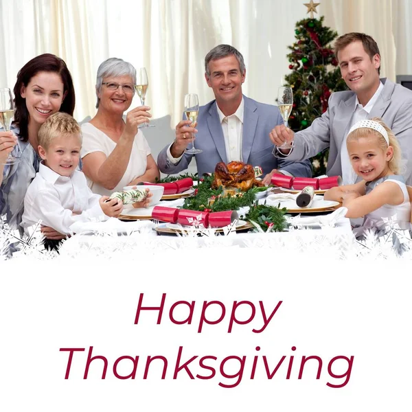 Happy thanksgiving text on white and happy caucasian family at celebration dinner table. Thanksgiving, harvest festival, american tradition, family and autumn celebration digitally generated image.