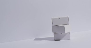 Beyaz arkaplan üzerinde kopyalama alanı olan karton kutuların videosu. Siber Pazartesi, Kara Cuma, çevrimiçi alışveriş, nakliye ve küresel bağlantılar kavramı.