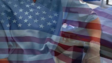 Hastanedeki cerrahi maskeli kadın cerrahın portresinin üzerinde ABD bayrağı sallama animasyonu. Küresel sağlık hizmeti kavramı