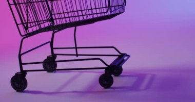 Neon mor arka planda fotokopi alanı olan alışveriş arabasının videosu. Siber Pazartesi, Kara Cuma, çevrimiçi alışveriş, nakliye ve küresel bağlantılar kavramı.