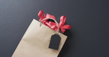 Hediye paketi videosu, hediye etiketi ve kırmızı kurdeleli hediye kutuları ve siyah arkaplanda kopyalama alanı. Siber Pazartesi, Kara Cuma, çevrimiçi alışveriş, nakliye ve küresel bağlantılar kavramı.