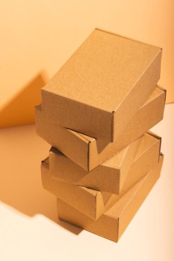 Sarı zemin üzerinde kopya alanı olan karton hediye kutularının dikey görüntüsü. Siber Pazartesi, Kara Cuma, çevrimiçi alışveriş, nakliye ve küresel bağlantılar kavramı.