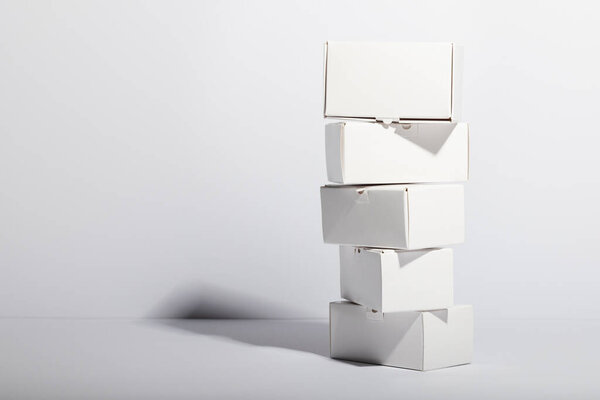 Стопка картонных подарочных коробок с копировальным пространством на белом фоне. Киберпонедельник, черная пятница, онлайн-покупки, доставка и глобальные связи.