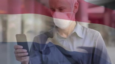Sokakta akıllı telefon kullanarak, beyaz maskeli bir adamın üzerinde Hollanda bayrağı sallamanın animasyonu. Küresel covid-19 salgın konsepti