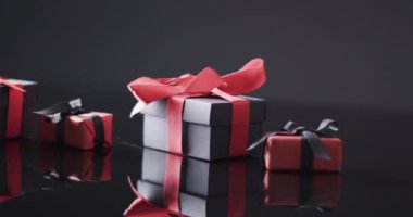 Kırmızı ve siyah kurdeleli hediye kutularının videosu ve siyah arkaplan üzerine kopyalama alanı. Siber Pazartesi, Kara Cuma, çevrimiçi alışveriş, nakliye ve küresel bağlantılar kavramı.