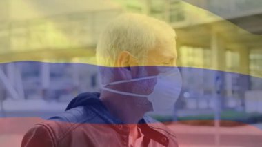 Sokakta yüz maskesi takan beyaz bir adamın portresinin üzerinde Kolombiya bayrağı sallama animasyonu. Küresel covid-19 salgın konsepti