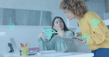 Wi-Fi, bulut ve GPS simgeleri, gündelik ofiste dizüstü bilgisayarda tartışılan çeşitli bayan meslektaşlar üzerinde. İnternet, iş, veri, dijital arayüz, bağlantı ve iletişim dijital olarak oluşturulmuş video.