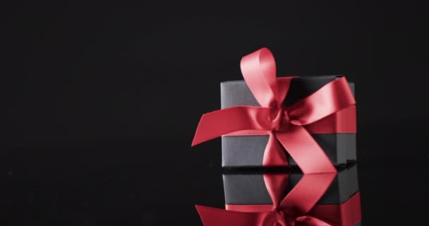 带红色缎带的礼品盒的视频 并复制黑色背景上的空间 网上星期一 黑色星期五 网上购物 航运和全球联系概念 — 图库视频影像