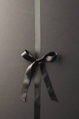 Siyah hediye kurdelesi ve siyah arka planda fotokopi alanı. Kara Cuma, siber pazartesi, alışveriş, siber alışveriş, satış, perakende ve nakliye konsepti.