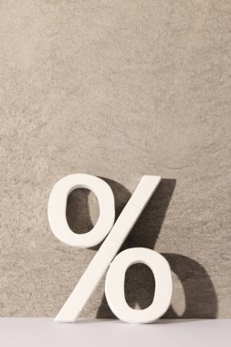 Gri duvarlı arka planda fotokopi alanı olan beyaz yüzde işareti. Kara Cuma, siber pazartesi, alışveriş, siber alışveriş, satış, perakende ve nakliye konsepti.