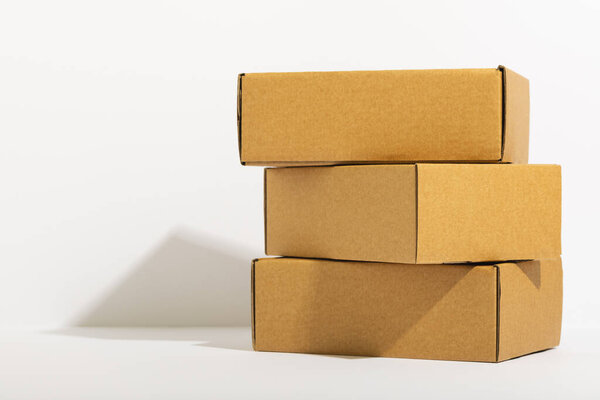 Stack of cardboard gift boxes with copy space over white background. Cyber monday, black friday, online shopping, shipping and global connections concept.