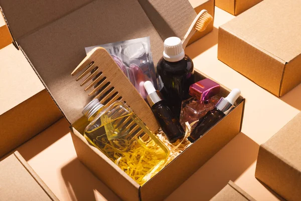 Box with beauty products, rows of boxes and copy space over cream background. Cyber monday, black friday, online shopping, shipping and global connections concept.
