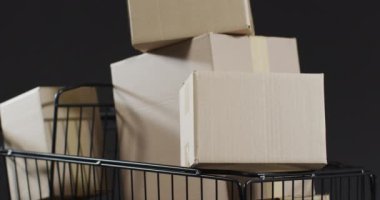 Alışveriş arabasının videosu ve gri arka planda fotokopi alanı olan kutular. Siber Pazartesi, Kara Cuma, çevrimiçi alışveriş, nakliye ve küresel bağlantılar kavramı.