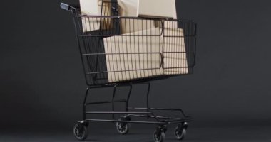 Alışveriş arabasının videosu ve gri arka planda fotokopi alanı olan kutular. Siber Pazartesi, Kara Cuma, çevrimiçi alışveriş, nakliye ve küresel bağlantılar kavramı.