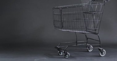 Gri arka planda fotokopi alanı olan alışveriş arabasının videosu. Siber Pazartesi, Kara Cuma, çevrimiçi alışveriş, nakliye ve küresel bağlantılar kavramı.