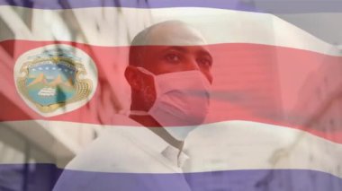 Sokakta yüzü maskeli Afro-Amerikan bir adam için Costa-rica bayrağı sallama animasyonu. Küresel covid-19 salgın konsepti