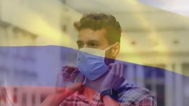 Sokak ortasında maskesini ayarlayan melez bir adama karşı Kolombiya bayrağı sallama animasyonu. Küresel covid-19 salgın konsepti
