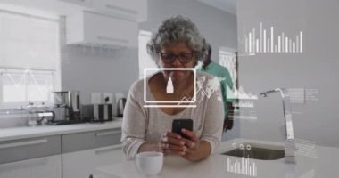 Grafik, harita ve dizüstü bilgisayardaki bulut animasyonları, cep telefonu kullanan yaşlı Afro-Amerikan kadını gösteriyor. Dijital bileşik, emeklilik, rapor, iş, küresel, bulut hesaplama ve teknoloji kavramı.