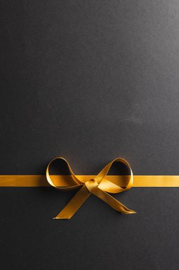 Altın hediye kurdelesi ve siyah arka planda fotokopi alanı. Kara Cuma, siber pazartesi, alışveriş, siber alışveriş, satış, perakende ve nakliye konsepti.