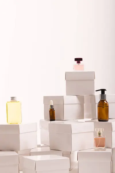 Vertical image of boxes with beauty products and copy space over white background. Cyber monday, black friday, online shopping, shipping and global connections concept.