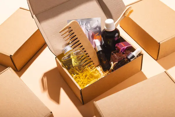 Box with beauty products, rows of boxes and copy space over cream background. Cyber monday, black friday, online shopping, shipping and global connections concept.