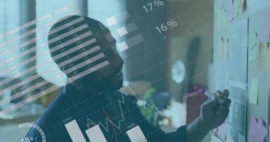 Afro-Amerikan bir adamın ofisteki notlara yazdığı istatistiksel veri işleme animasyonu. Bilgisayar arayüzü ve iş veri teknolojisi kavramı