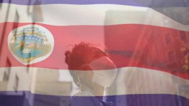 Sokakta yüzünde maske olan Asyalı bir kadına karşı Costa rica bayrağı sallama animasyonu. Küresel covid-19 salgın konsepti