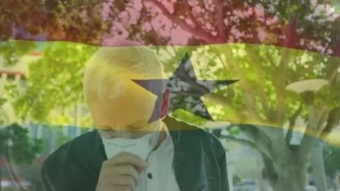 Caddede öksüren yüzü maskeli beyaz bir adama karşı Gana bayrağı sallama animasyonu. Küresel covid-19 salgın konsepti