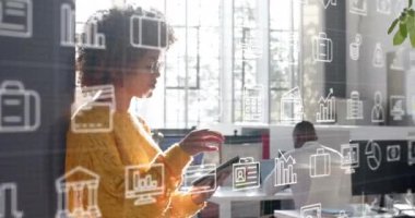 Medya simgelerini, ofiste tablet kullanan düşünceli çift ırklı iş kadınının üzerine kaydırmak. Günlük iş, veri, dijital arayüz, bağlantı, ofis ve iletişim dijital olarak oluşturulmuş video.