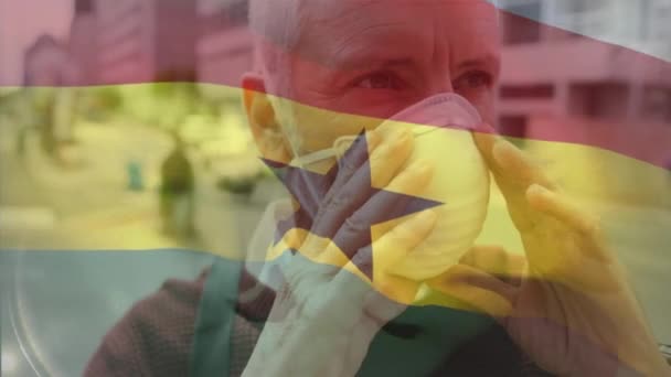 Animacja Wymachująca Flagą Ghany Przeciwko Białemu Mężczyźnie Ustawiającemu Maskę Ulicy — Wideo stockowe