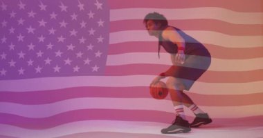 Amerikan bayrağının Afro-Amerikan erkek basketbolcu üzerinde zıplaması. Spor, rekabet, güven, beceri, bayrak, oyun, milliyet ve vatanseverlik dijital olarak üretilen video.