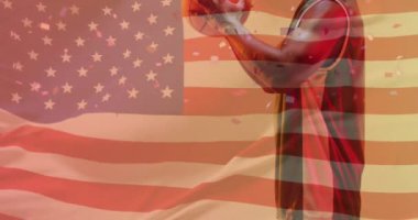 Amerikan bayrağının animasyonu, topu tutan Afrika kökenli Amerikalı erkek basketbolcu üzerinde. Spor, rekabet, güven, bayrak, takım, oyun, milliyet ve vatanseverlik dijital olarak üretilen video.