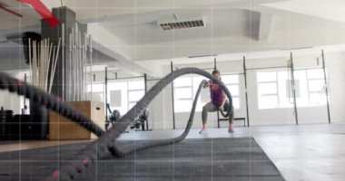 Beyaz bir kadının spor salonundaki savaş halatlarıyla çapraz eğitimle ilgili grafik işleme verilerinin animasyonu. Fitness, egzersiz, güç, veri, dijital arayüz ve dijital olarak üretilen video.