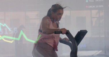 Grafik üzerinde veri işleme animasyonu. Spor salonunda eliptik üzerinde melez bir kadının çapraz eğitimi. Fitness, egzersiz, güç, veri, dijital arayüz ve dijital olarak üretilen video.