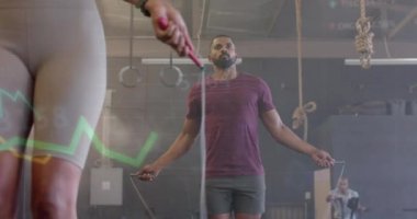 Değişik kadın ve erkeklerin spor salonunda ip atlama eğitimleri üzerine veri işleme animasyonu. Fitness, egzersiz, güç, veri, dijital arayüz ve dijital olarak üretilen video.