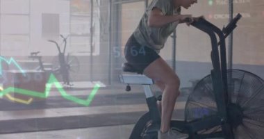 Grafik üzerinde veri işleme animasyonu. Spor salonunda eliptik üzerinde melez bir kadının çapraz eğitimi. Fitness, egzersiz, güç, veri, dijital arayüz ve dijital olarak üretilen video.