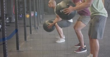 Çeşitli erkek gruplarının spor salonundaki tıp toplarıyla çapraz eğitimlerinin grafik işleme verilerinin animasyonu. Fitness, egzersiz, güç, veri, dijital arayüz ve dijital olarak üretilen video.