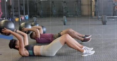 Çeşitli erkek ve kadınların spor salonunda tıp toplarıyla çapraz eğitimlerinin grafik işleme animasyonu. Fitness, egzersiz, güç, veri, dijital arayüz ve dijital olarak üretilen video.