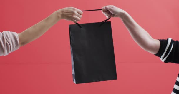 白人妇女手拿着黑色购物袋的视频 带有红色背景的复制空间 黑色星期五 网络星期一 网络购物 零售和航运概念 — 图库视频影像
