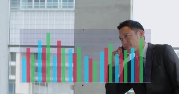 Ofiste Cep Telefonuyla Konuşan Asyalı Adamın Çok Renkli Bar Grafiklerinin — Stok video