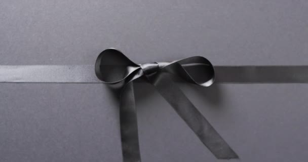 黑色礼品带和弓的视频 背景为黑色 有复制空间 黑色星期五 网络星期一 网络购物 零售和航运概念 — 图库视频影像