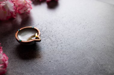 Diwali mumunu ve çiçekleri kapatın ve gri arkaplanda fotokopi alanı olsun. Diwali, ışık, din, hindu geleneği ve kutlaması festivali.