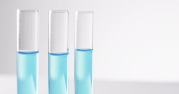 玻璃实验室试管和带蓝色液体的吸管的视频 并在白色背景上复制空间 研究和化学概念 — 图库视频影像