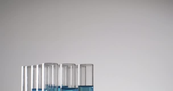 带蓝色液体的玻璃实验室试管的录像 在白色背景上有复制空间 研究和化学概念 — 图库视频影像